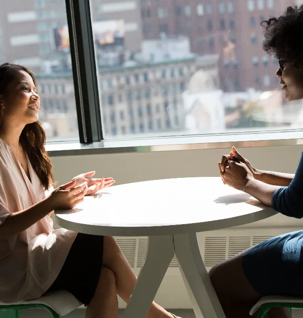 Two professionals in conversation at a table